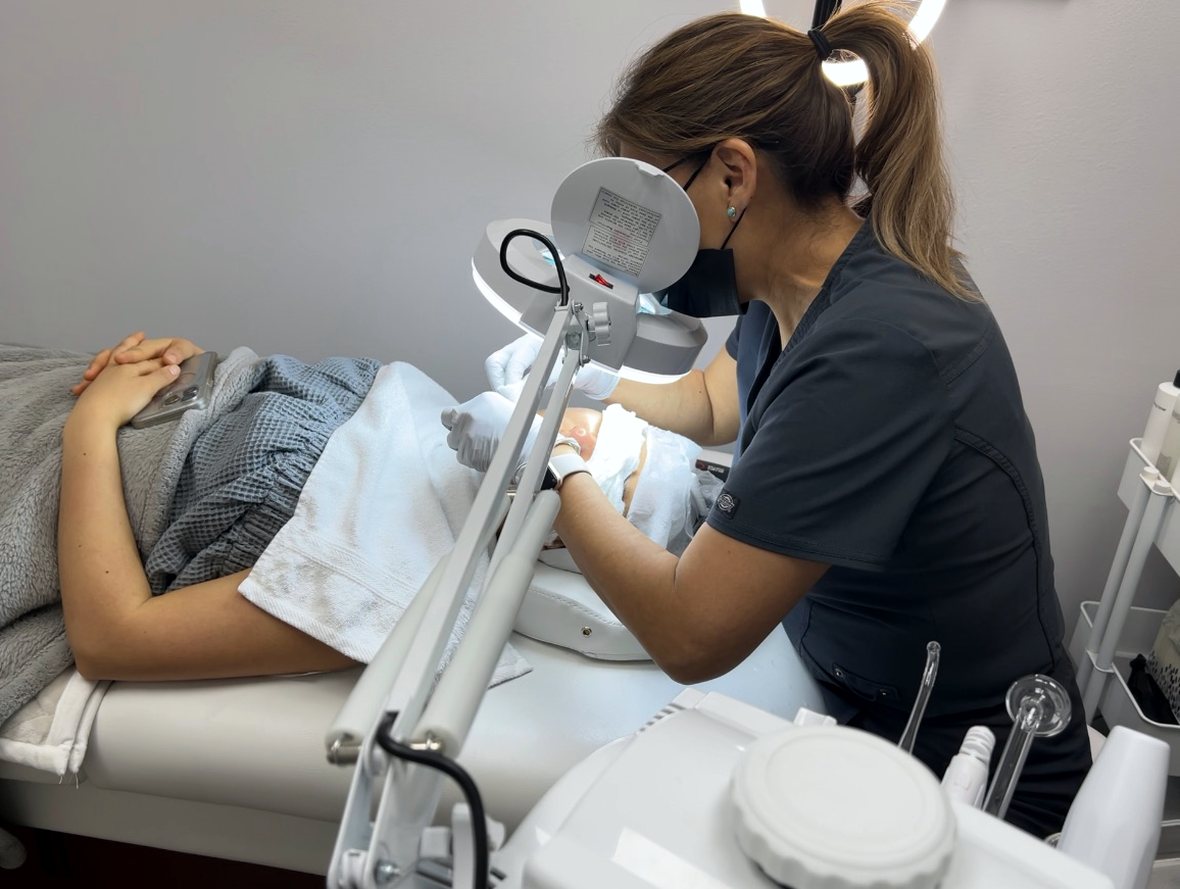 The esthetician treating a client in the Touch Laser Spa room